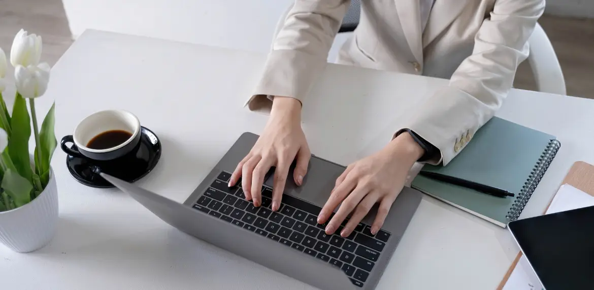 Female hands working on modern laptop. Office desktop on white background