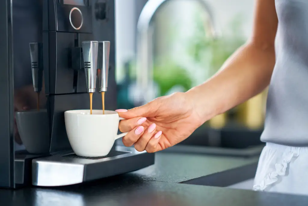 Nice woman making coffee in the kitchen
